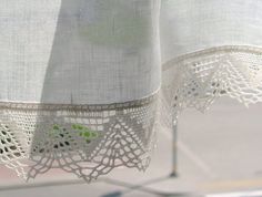 white curtains with crocheted lace hanging from them