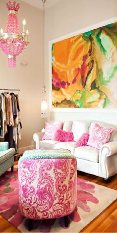 a living room filled with furniture and a chandelier hanging from the ceiling above it