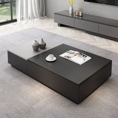 a modern living room with grey carpeting and black coffee table in front of a large window