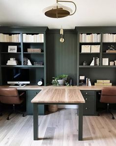 an office with two desks, chairs and bookshelves in the center of the room