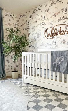 a baby's room with a white crib and wallpaper