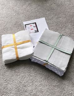 three folded towels on the floor next to each other with a yellow ribbon tied around them