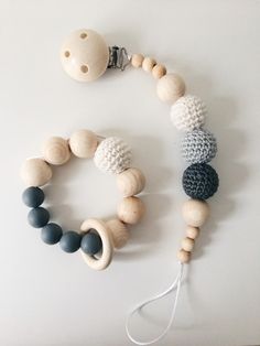 two wooden beads and a pacifier on a white surface with a string attached to it