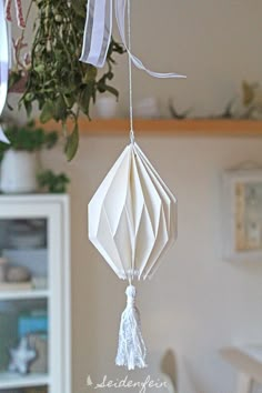 a white origami hanging from a ceiling