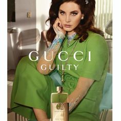 a woman sitting on top of a chair next to a bottle of guccili