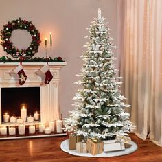 a decorated christmas tree sitting in front of a fire place with candles on the mantle