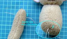 a teddy bear is being made with sewing needles and needle tips on a blue surface