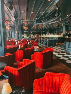 an empty restaurant with red velvet chairs and checkered flooring on the walls is pictured