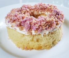 a white plate topped with a donut covered in frosting and sprinkles