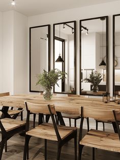 a dining room table and chairs with mirrors on the wall