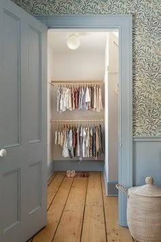 an open door leading to a closet with clothes on hangers