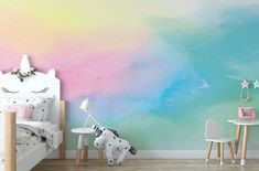 a child's room with a wall painted in pastel colors and unicorn themed furniture