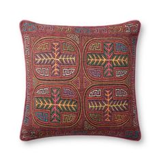 a red pillow with an embroidered design on it