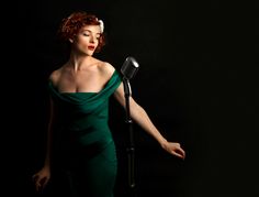 a woman in a green dress holding a microphone