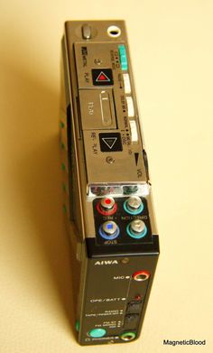 an electronic device sitting on top of a white table next to a black and blue button