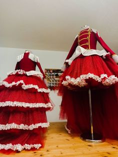 two mannequins dressed in red and white tulle dresses, one with long sleeves