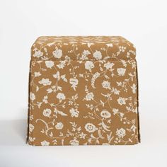 a brown and white flowered box sitting on top of a table