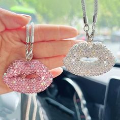 a person holding two necklaces in their hand and the other one has a kiss on it