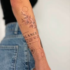 a woman with a tattoo on her arm that reads balance and has flowers in it