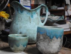 a pitcher and two cups sitting on a table