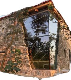 an old brick building with trees reflected in the windows