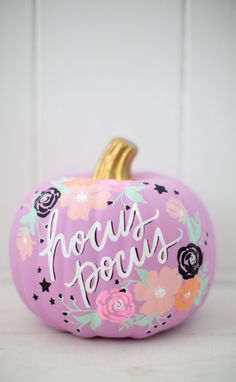 a pink painted pumpkin with flowers and the words hocps ponies written on it