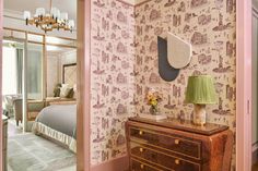 the bedroom is decorated in pink and gold with a bed, dresser, mirror and lamp