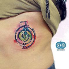 a woman's stomach with a colorful tattoo on it and an abstract design in the middle