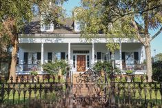 a white house with black wrought iron fence