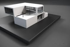 an architectural model of a house on top of a black surface with white walls and windows