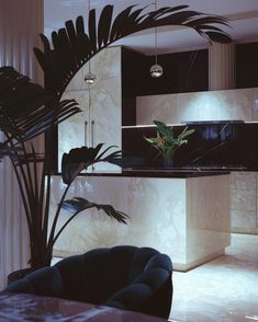 a modern kitchen with marble counter tops and black chairs in front of an island that has palm leaves on it