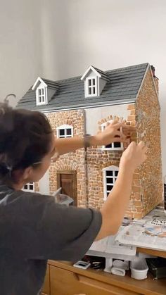 a woman is building a house out of cardboard