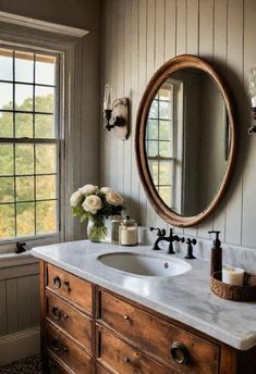 a bathroom with a sink, mirror and window