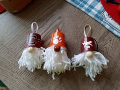 three little gnomes made out of toilet paper on a table with other items in the background