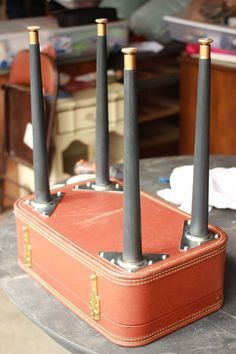 a suitcase sitting on top of a table with four black poles sticking out of it