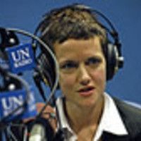 a young man wearing headphones in front of a microphone with an un logo on it