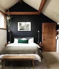 a bedroom with black walls and white bedding