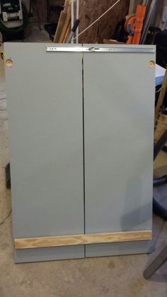 a gray cabinet sitting inside of a garage