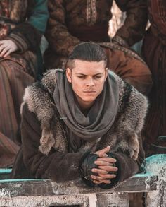 a young man dressed in medieval clothing sitting on steps