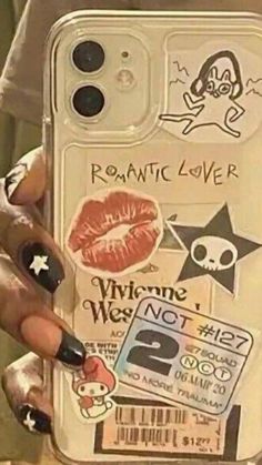 a person holding up a phone case with stickers on it