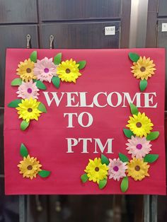 a pink sign with yellow and pink flowers on it that says welcome to ptm