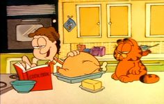 an image of garfield the cat reading to a child in the kitchen with his dog