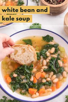 a hand holding a piece of bread over a bowl of white bean and kale soup