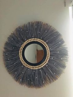 a round mirror hanging on the side of a wall