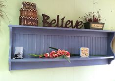 there is a shelf with flowers on it and a sign above it that says believe