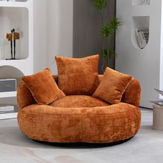 a living room with an orange chair and bookshelves on the wall behind it