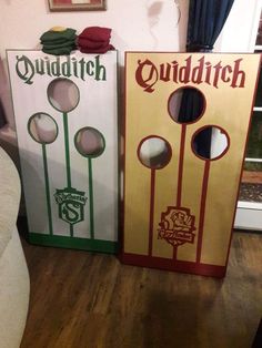 two cornhole game boards sitting on top of a wooden floor next to a couch