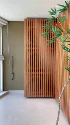 a bamboo screen in the corner of a room next to a window with a shower