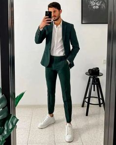 The bold yet refined look of a dark green suit paired with sneakers is a classic combination that can be your go-to for the special night. Suit: A white shirt topped with a dark green blazer which is paired with matching dress pants, offering a balanced classy look. Footwear: A pair of white sneakers complete the outfit, balancing out the dark hues of the suit like none other. Coat Pant For Men, Men Dressing, Terno Slim, Wedding Kurta, Suit Styles, Mens Smart Casual Outfits