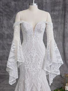 a white wedding dress with long sleeves on a mannequin